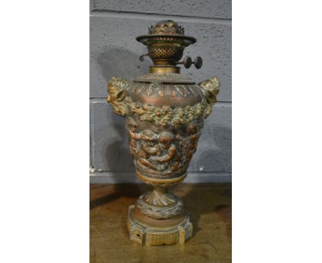A 19th Century copper and plated oil lamp mounted with bass style handles and embossed with merry making cherubs, signed J.G 
