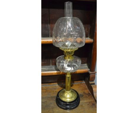 An Edwardian brass oil lamp with clear shade and reservoir on stepped black base, height 58cm