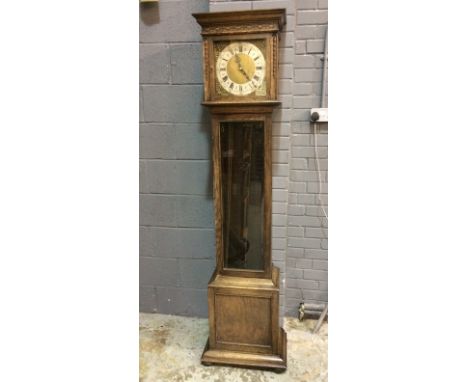 A 20th Century oak longcase clock with 30 hour striking movement brass dial and silver chapter ring enclosed by a fluted hood