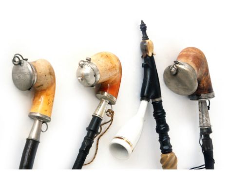 A 19th Century Meerschaum pipe with flexible hose and mouth piece two other similar pipes and an example with a glazed cerami