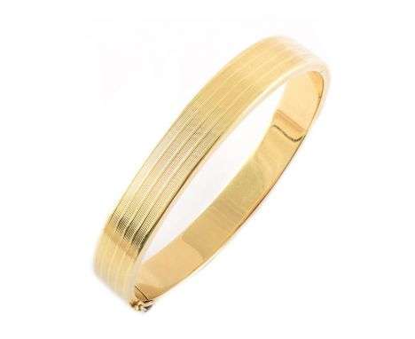 A 14ct yellow gold hinched bangle, engine turned, line pattern, tongue box snap clasp with safety clip, 11mm diameter, gross 