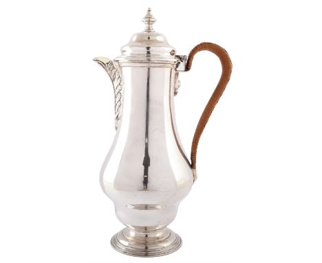 Silver hot water jug , plain polished baluster form body on pedestal foot, applied floral decoration to spout, urn shaped fin