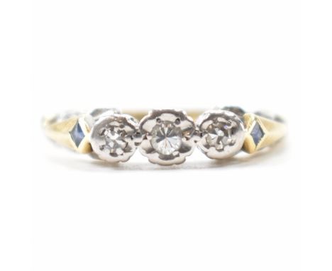 A hallmarked 18k gold &amp; diamond ring. Having three round brilliant cut illusion set diamond flanked by two diamond cut bl