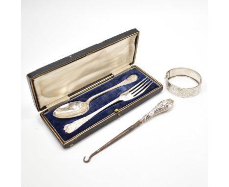 A silver hallmarked spoon and fork cased set, button hook and bangle bracelet. The spoons and fork having engraved details to