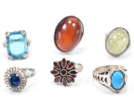 A collection of silver &amp; white metal stone set rings. The lot to include; three cabochon stone set rings, a floral red st