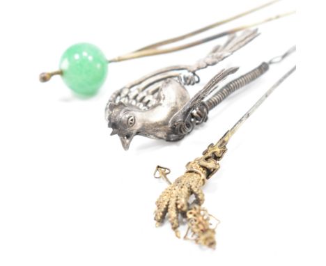 A group of antique hair pins. To include; a two pronged hair pin with large green bead accent, a spring articulated&nbsp;en t