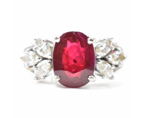 A hallmarked 18ct white gold, ruby and diamond ring. Principle ruby measures 10mm x 7mm. Flanked by 6 marquise cut diamonds, 