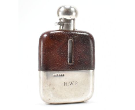 A hallmarked silver and leather 1/4 pint hip flask. The flask having partial leather cover with level window having silver hi