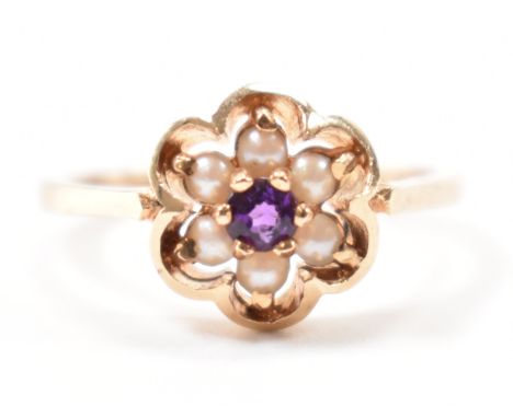 A hallmarked 9ct gold amethyst and seed pearl cluster ring. The ring being set with a round cut amethyst surrounded by six se