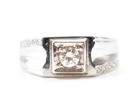 An 18ct white gold &amp; diamond ring. The ring having a central bright cut set round brilliant cut diamond with five surface