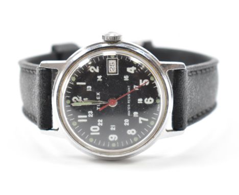 A vintage Timex military style wrist watch. The watch having a round black face with arabic numerals to the chapter ring with