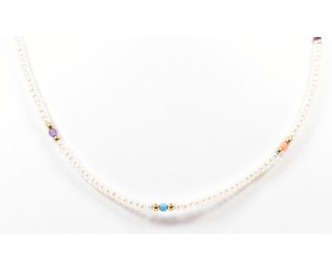 A gold, cultured pearl and coloured stone bead necklace. The necklace threaded with white cultured pearls with gold spacer be