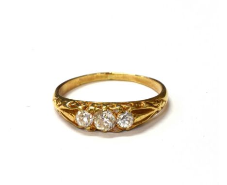 ESTATE DIAMOND THREE STONE RING An old mine cut diamond flanked by two old European cut diamonds with senaille cut diamond ac