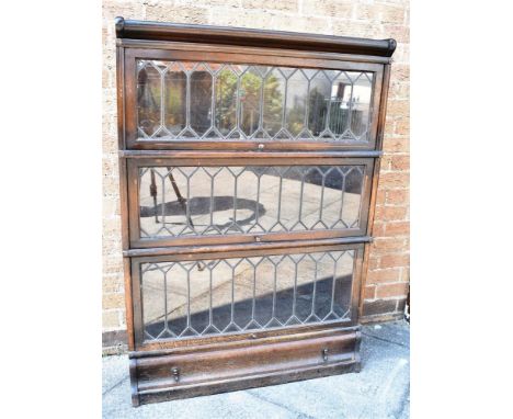 AN OAK THREE TIER GLOBE WERNICKE SECTIONAL BOOKCASE  with lead glazed up and over doors and drawer to base, 87cm wide 31cm de