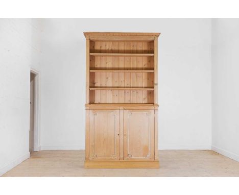 A George III-style stripped pine bookcase, late 19th/early 20th century, with a dentil-moulded cornice, above open shelves an