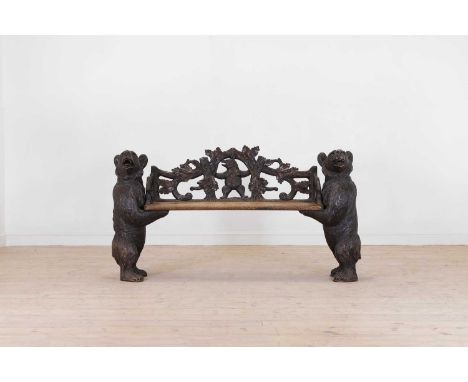 A Black Forest carved wooden bench, late 19th/early 20th century, Swiss, with a pierced back decorated with oak leaves, and a