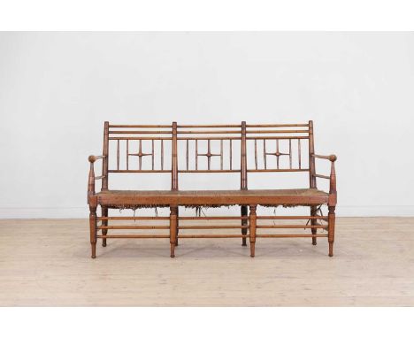 A late Victorian Aesthetic period walnut bench, c.1880, in the 'Sussex' style with turned decoration, the high back and open 
