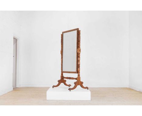 A Regency mahogany cheval mirror, c.1820, with an adjustable mercury glass plate set between a pair of foliate-carved ring-tu