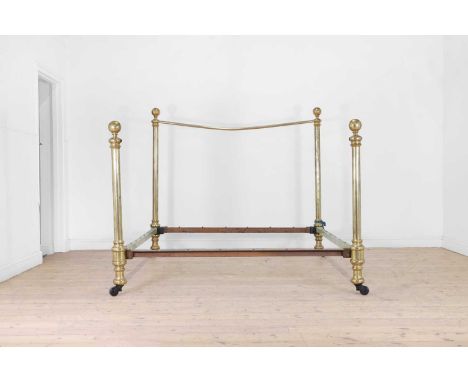 A Victorian polished brass double bed, c.1880, with large tubular supports and ceramic castors,175cm wide215cm long152cm high