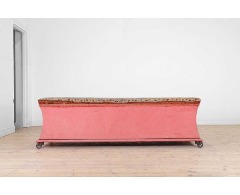 A large upholstered ottoman, 20th century, with a hinged lid covered with an antique Oushak carpet fragment, above a waisted 