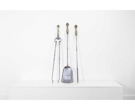 A set of three Regency brass and steel fire tools, 19th century, each with rococo handles, comprising a shovel, poker and ton
