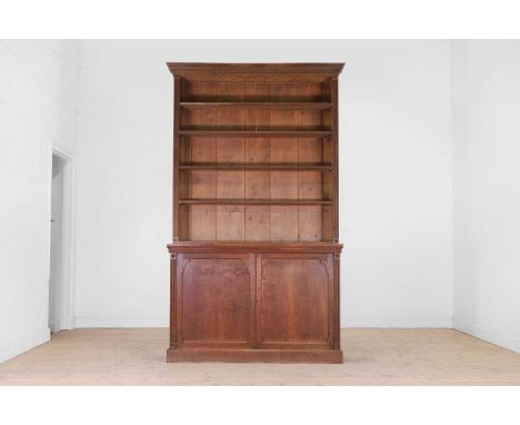 A Regency-style oak bookcase, second half of the 19th century, with a stepped dentil-moulded cornice above open shelves and a