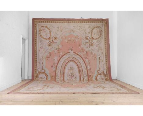 A large Aubusson-style needlepoint carpet, 20th century, the ivory fields with all-over foliate decoration within a plain red