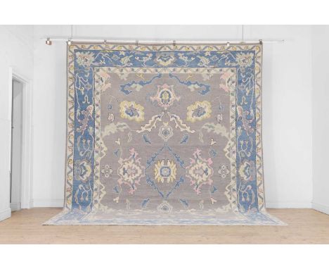 An Oushak wool carpet, of recent manufacture, woven in tones of blue with floral and foliate motifs, 369 x 284cmCondition Rep