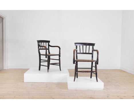 A pair of Victorian ebonised beech elbow chairs, c.1880, each with bobbin detail and a caned seat, raised on outplayed suppor