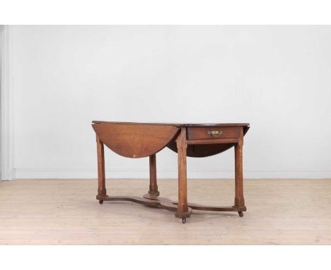 A provincial oak drop-leaf dining table, late 18th/early 19th century, French, the folding oval top above end drawers and cha