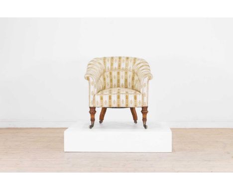 A late Victorian tub chair in the manner of Howard and Sons, c.1890, upholstered in foliate fabric and raised on ring-turned 