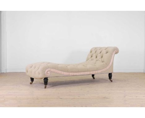 A late Victorian ebonised wooden chaise longue, c.1890, with buttoned upholstery and ring-turned supports, terminating in cer