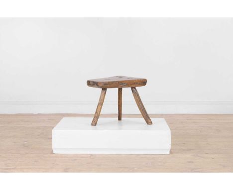 A small vernacular elm milking stool, 19th century, of asymmetrical tripod form, 41cm wide34cm deep30cm highCondition ReportG