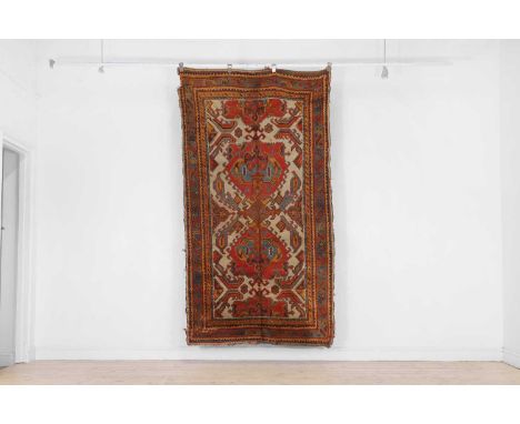 An Oushak wool rug, early 20th century, Turkish, woven with geometric foliate motifs to a pale ground, 237 x 130cmProvenance: