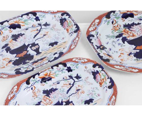 A graduated set of three Victorian Tonquin China ironstone meat dishes, 19th century, each decorated with vases of flowers an