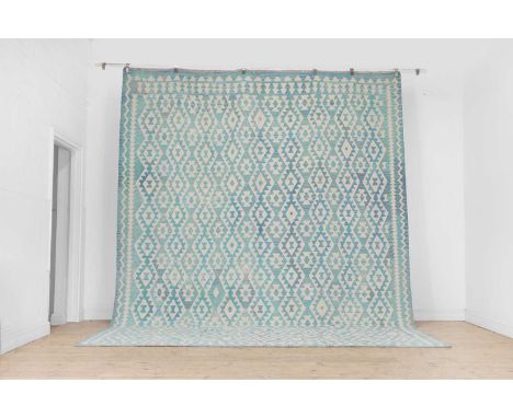 A kilim flat-weave wool carpet, of recent manufacture, woven with geometric motifs in tones of turquoise and cream, 385 x 310