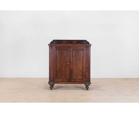 A William IV mahogany cupboard, c.1830, with an arched superstructure, above a rounded rectangular top and a pair of cupboard