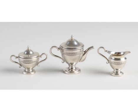 Three piece 800/000 silver miniature empire style coffee service. Equipped with ear handles, decorative edge and standing on 