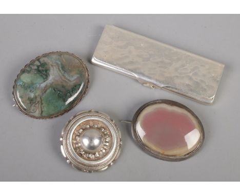 A WMF white metal stamp case along with three brooches. Includes a silver target brooch.  