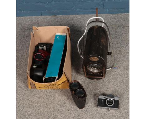 A box of assorted cameras to include boxed lens, film rolls, pair of binoculars and vintage studio light.  