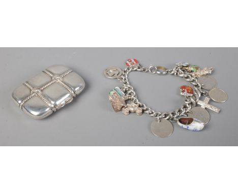 A silver charm bracelet containing an assortment of silver and enamel charms, together with a silver quilted pill box, with g