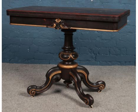 A Victorian fold-over card table, with gilt highlights, green baize insert and cabriole supports, raised on casters.  Require