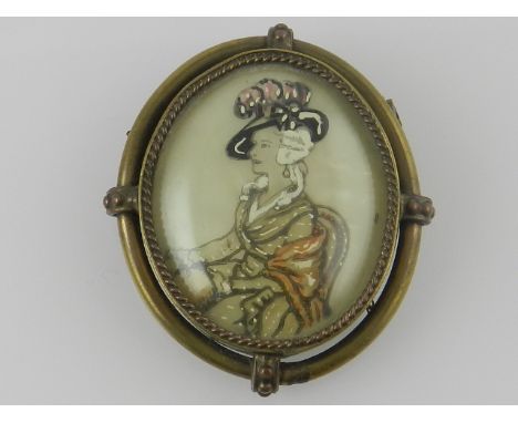 A metal framed brooch centred with a portrait of a lady. 