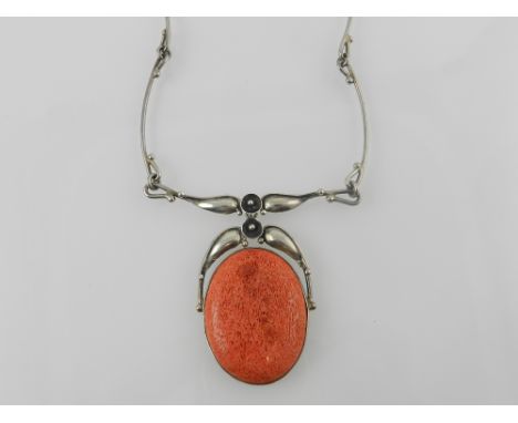 An Art Nouveau style white metal and red stained coral necklace and pendant