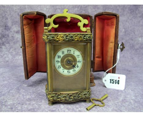 An Early XX Century Carriage Clock, the shaped rectangular brass case applied with foliate scrolls, bevelled glass panels, wi