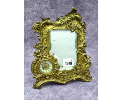 A Late XIX Century Dressing Table Mirror, with inset clock, the ormolu mount elaborately cast with flowers and scrollwork, th