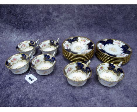 A Coalport 'Batwing' Pattern Porcelain Part Tea Service, decorated with floral sprays within dark blue and gilt panels, print