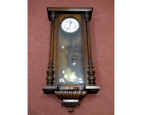 A Late XIX Century Vienna Wall Clock, in a walnut case, the white enamel dial with Roman numerals with turned pilasters, 88cm
