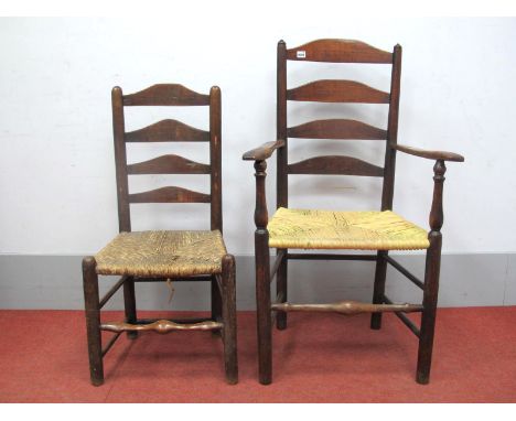 An Early XIX Century Ash and Elm Ladder Back Armchair, with shaped arms and rushed seat on turned round legs united by stretc