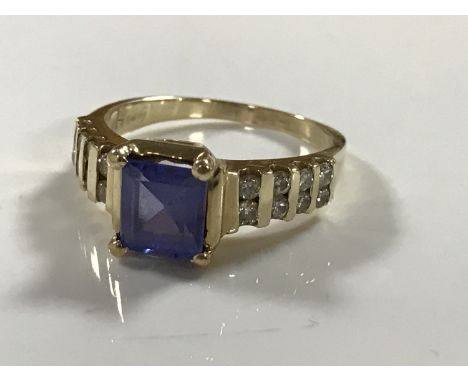 A 14ct gold diamond ring, set with a square cut blue stone (probably tanzanite), 4.5g, size M/N.